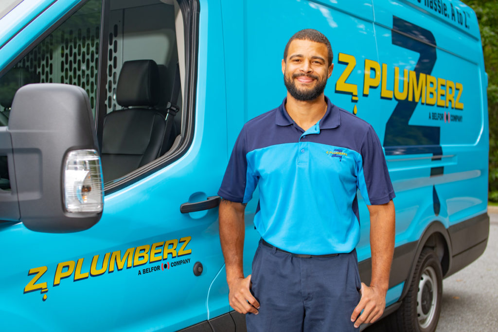 Z PLUMBERZ franchise owner stands with van / Become a Plumber